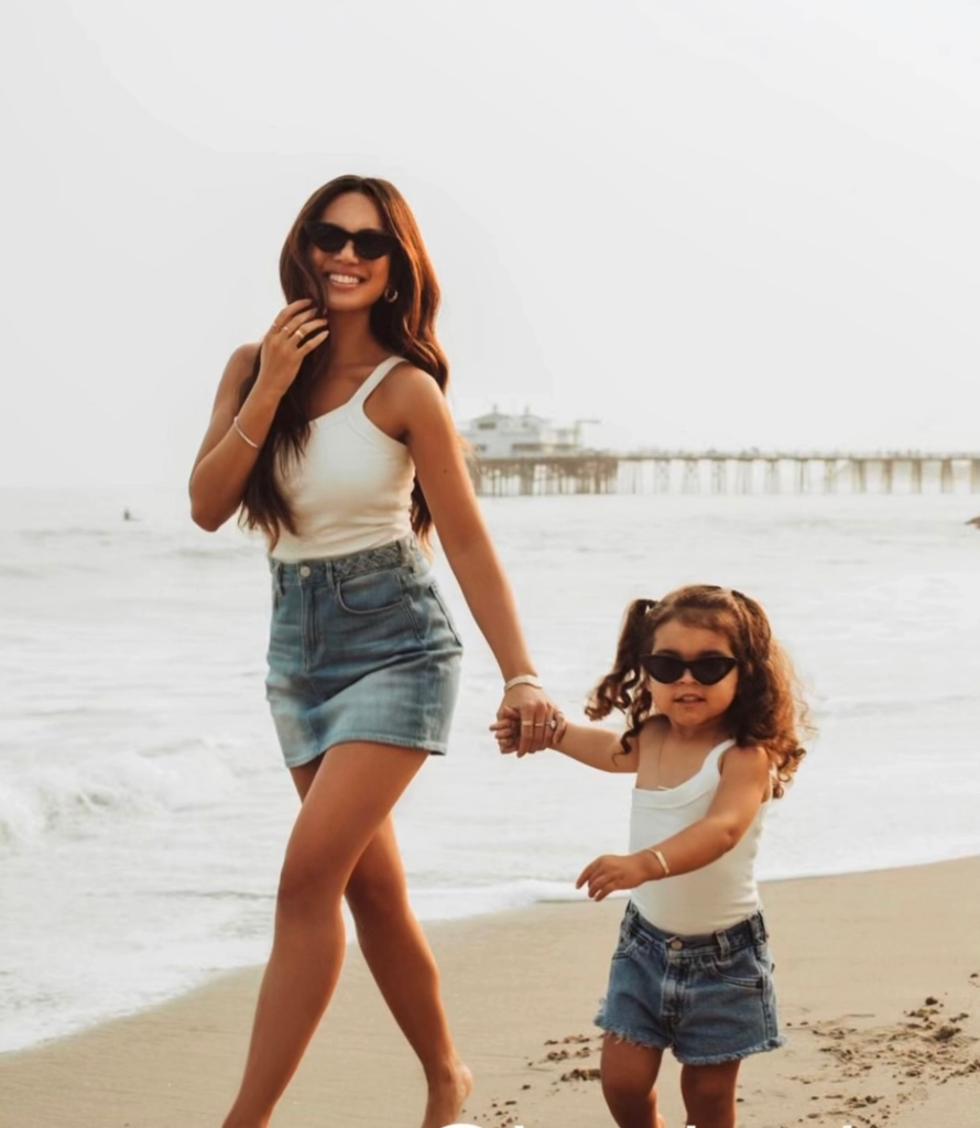 mom and daughter in matching black glasses on the beach